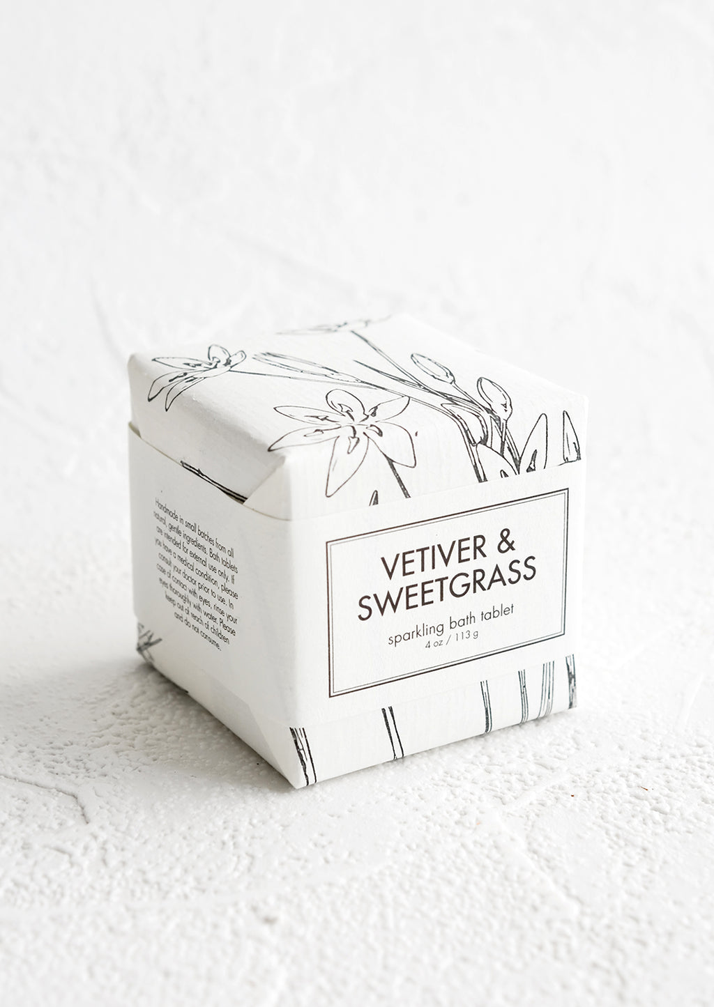 Vetiver & Sweetgrass: A cube-shaped bath fizzy box with black and white botanical graphic packaging.