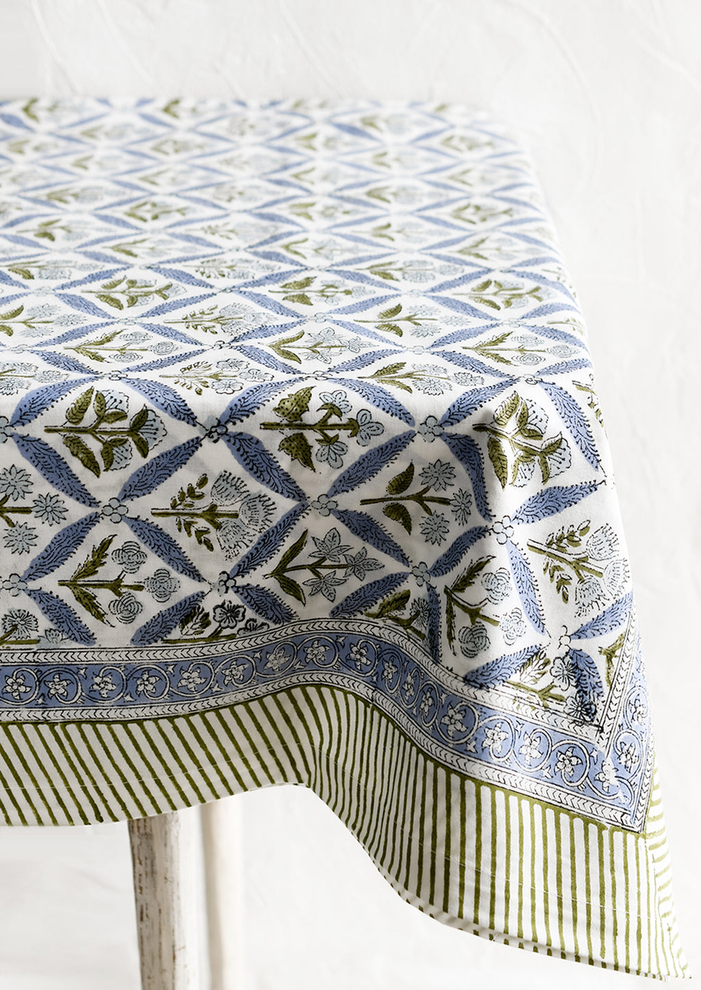 2: A block printed floral tablecloth in blue and green.