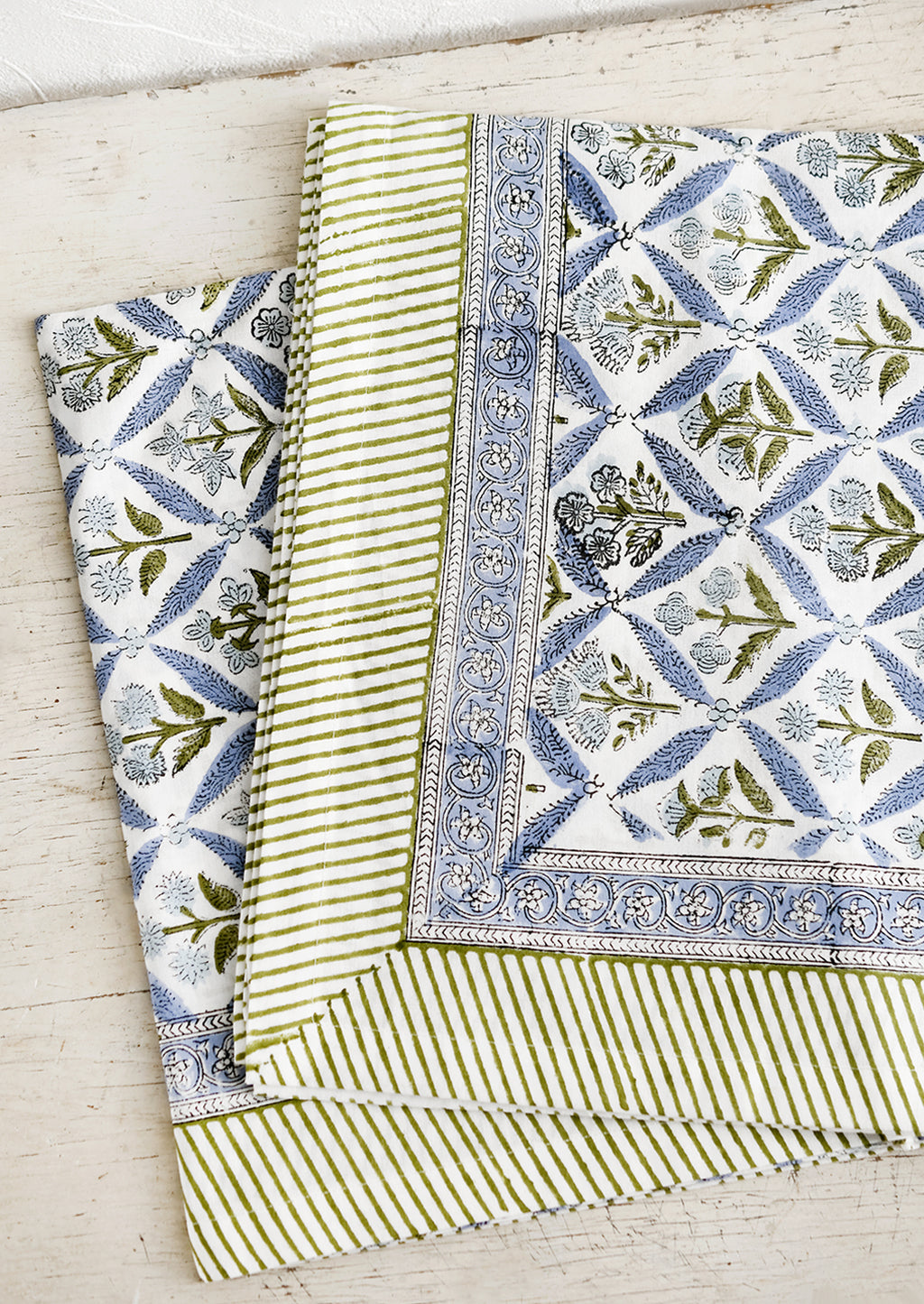 1: A block printed floral tablecloth in blue and green.