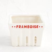 Framboise (Raspberry): A white ceramic basket designed to look like a berry basket with "Framboise" printed in red lettering.