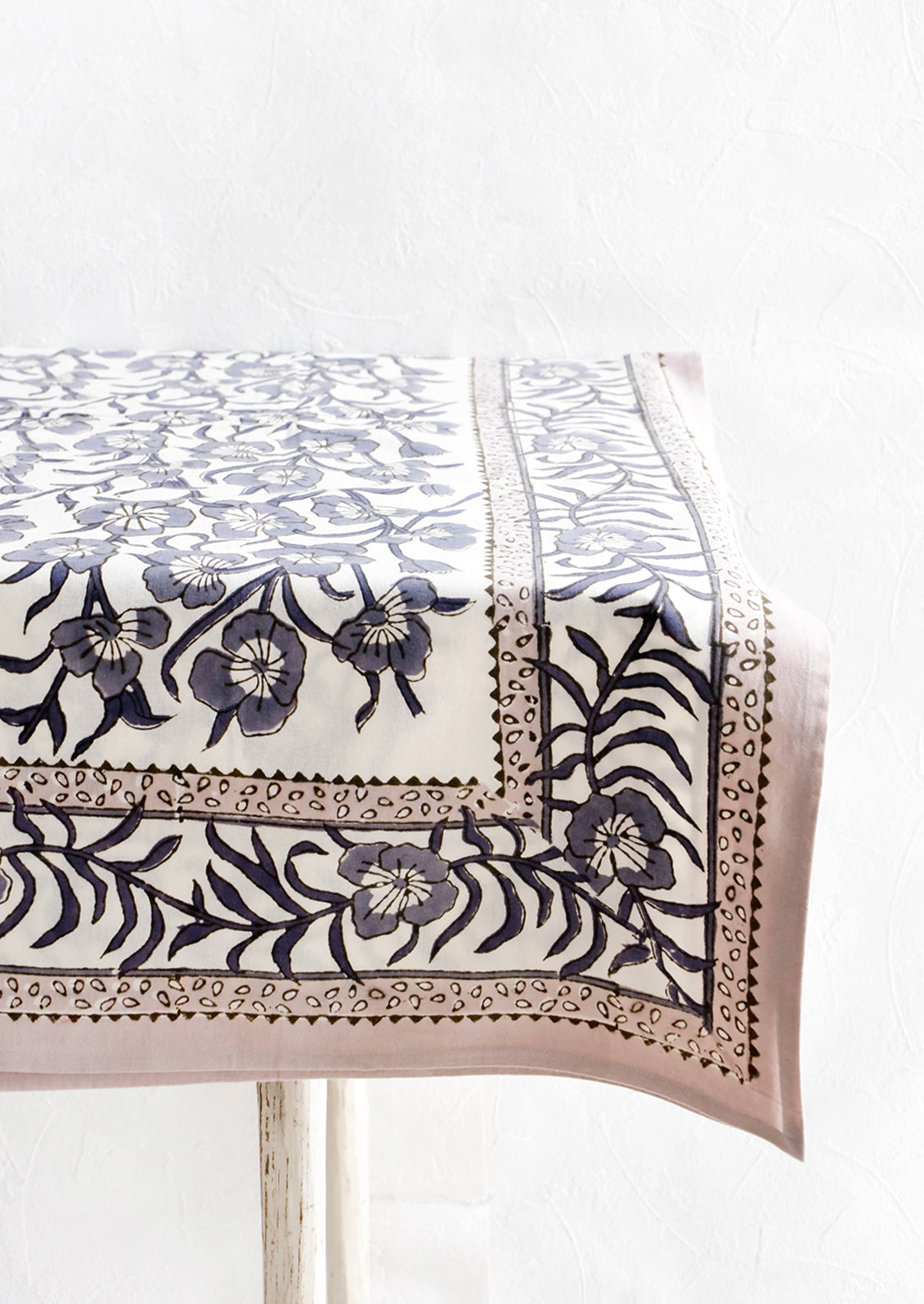 Tablecloth featuring bordered floral pattern displayed on a table.