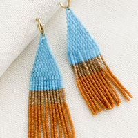 Turquoise Multi: Beaded earrings featuring turquoise and brown beads layered into fringe, dangling from a gold hoop.