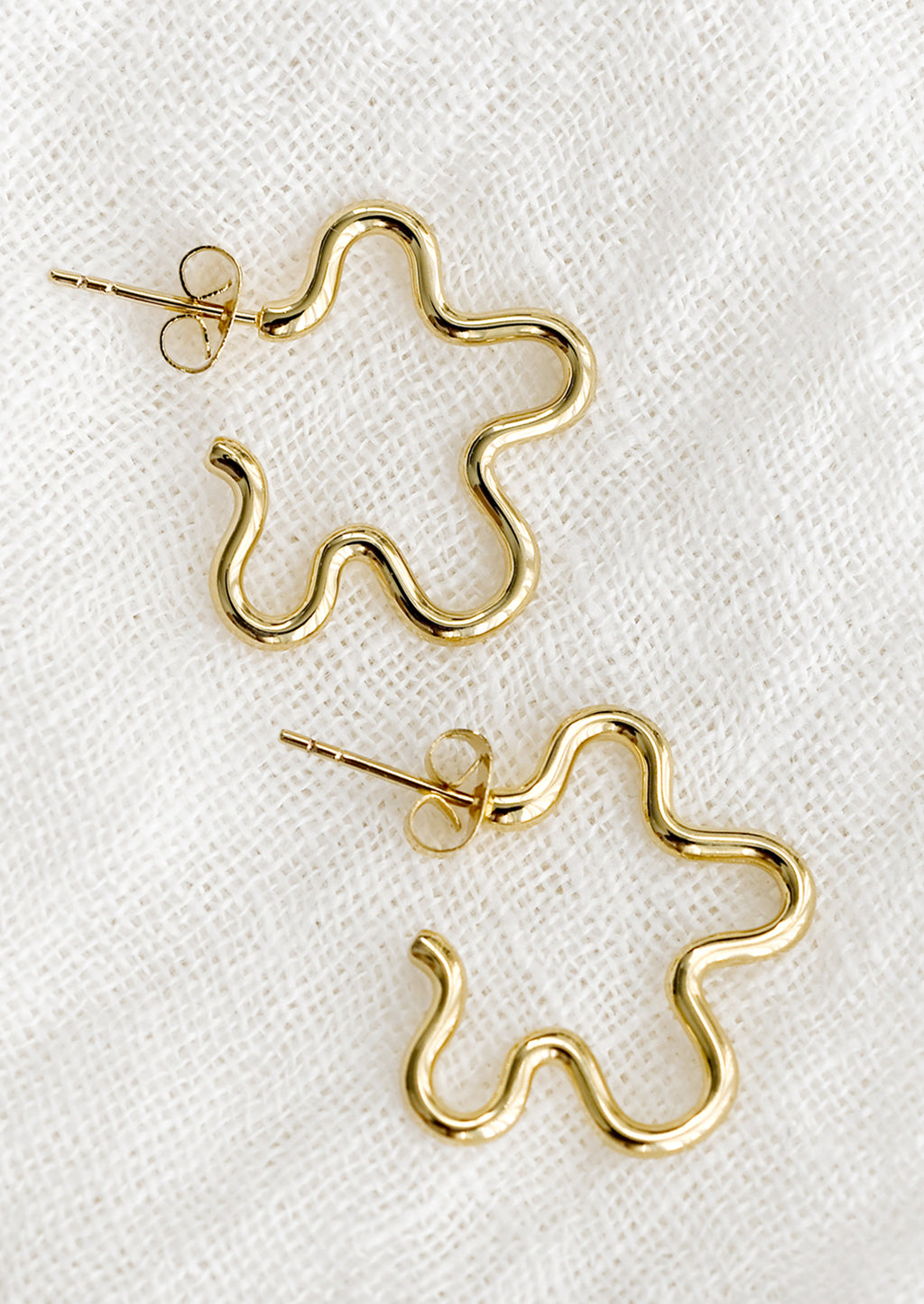 1: A pair of gold flower outline earrings.