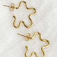 1: A pair of gold flower outline earrings.