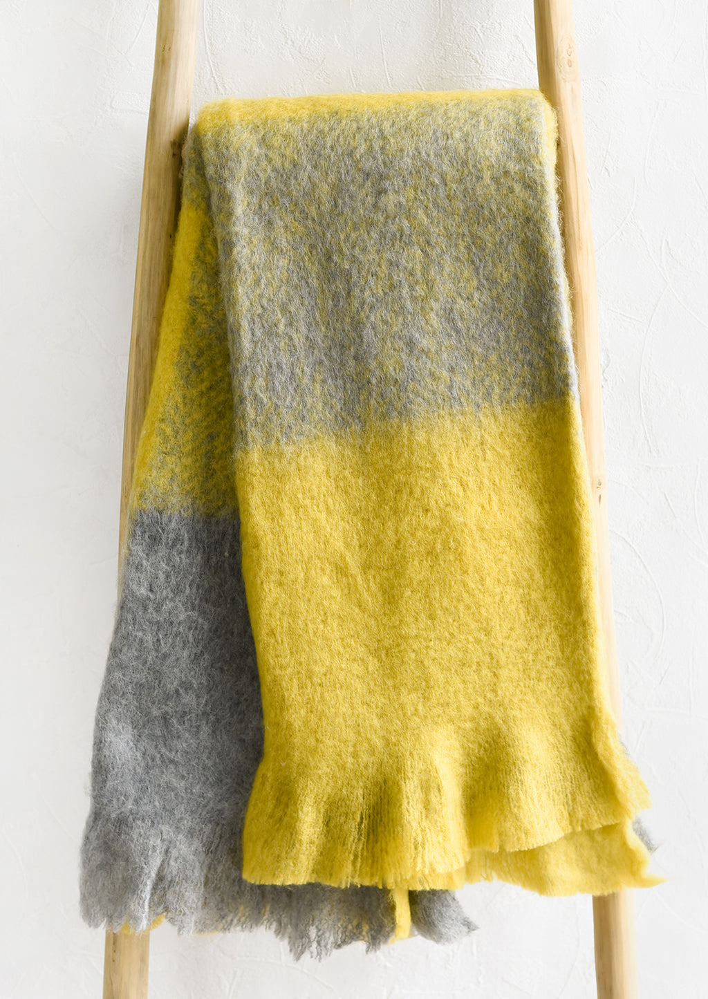 1: A mohair throw in grey and yellow.