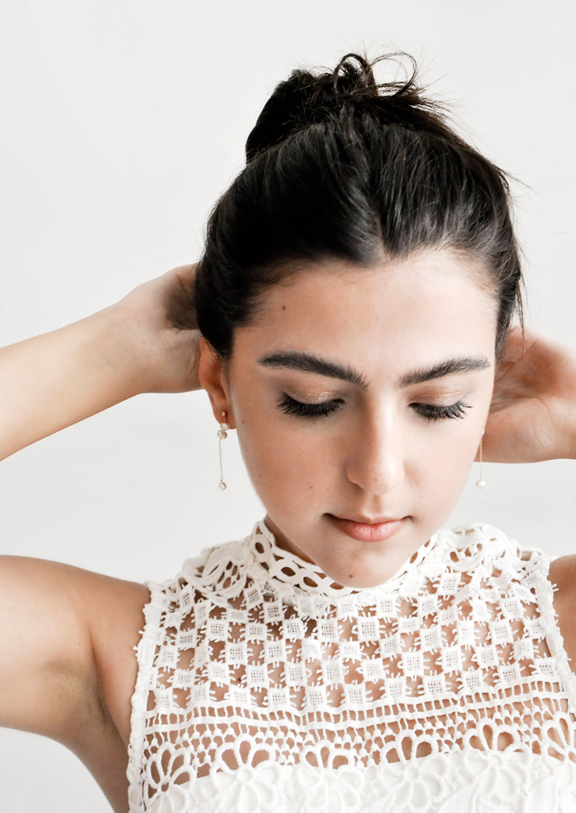 Model shot showing women wearing dangling earrings and a white top.