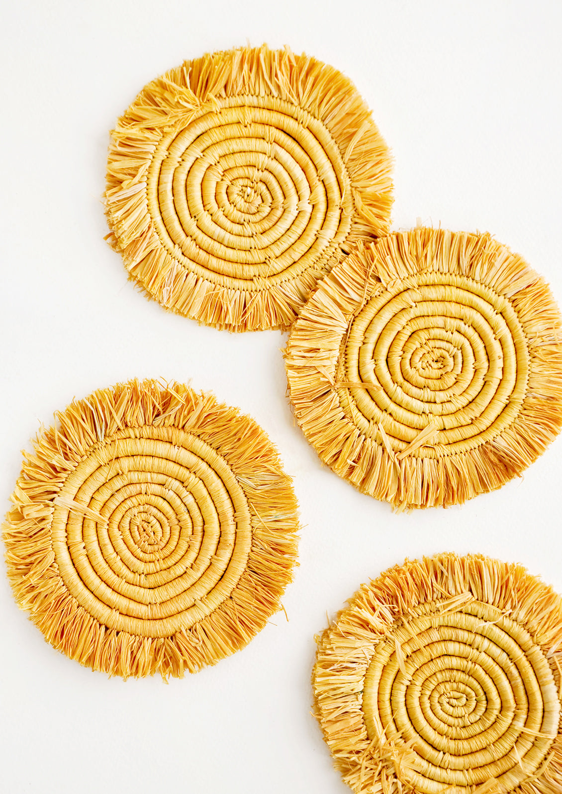 Set of 4 Circular Raffia Coasters with Fringed Trim in Yellow