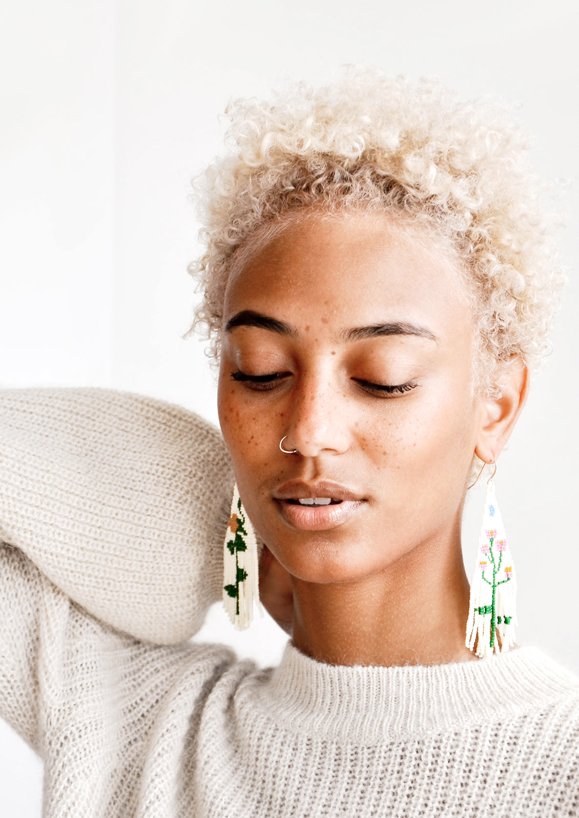 Model wears floral beaded fringe earrings.