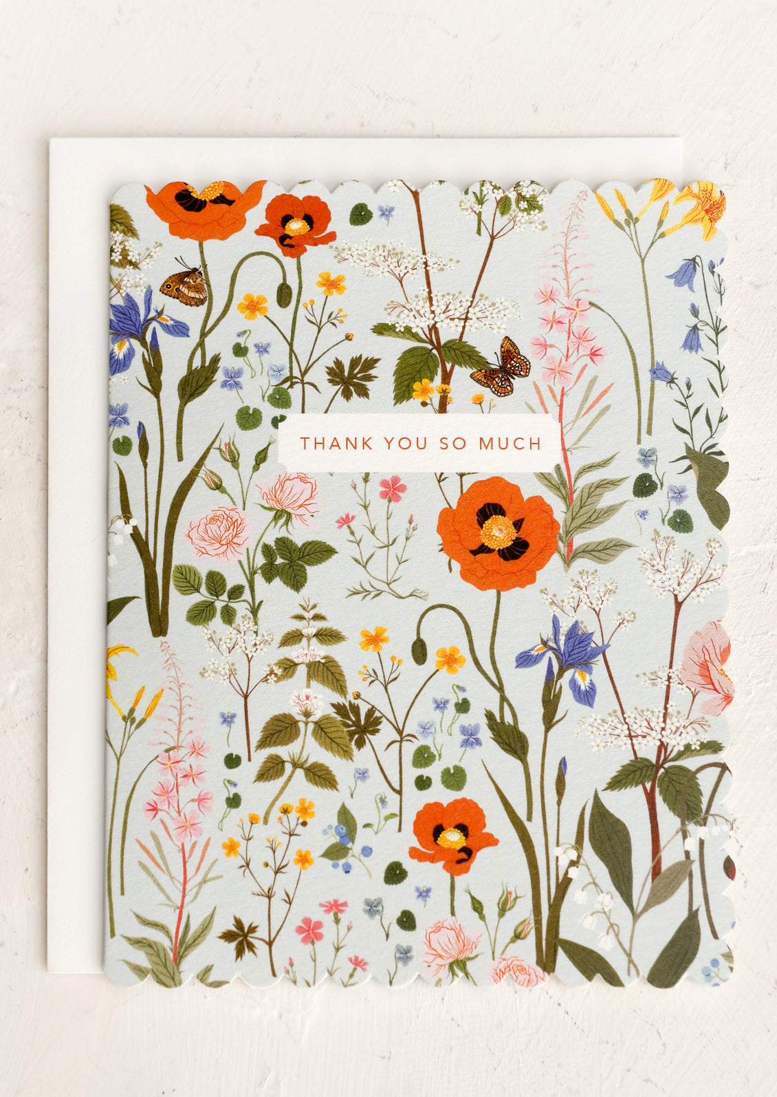 A scalloped edge greeting card with floral print reading "Thank you so much".