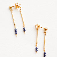 Sapphire: Two part dangling earrings featuring gold post and blue beads hanging from each of the post and the earring back.