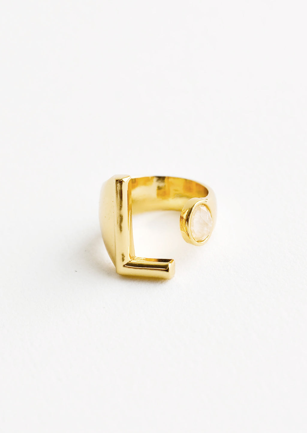 11: Yellow gold ring with letter L and oval glass crystal, and wide adjustable band.