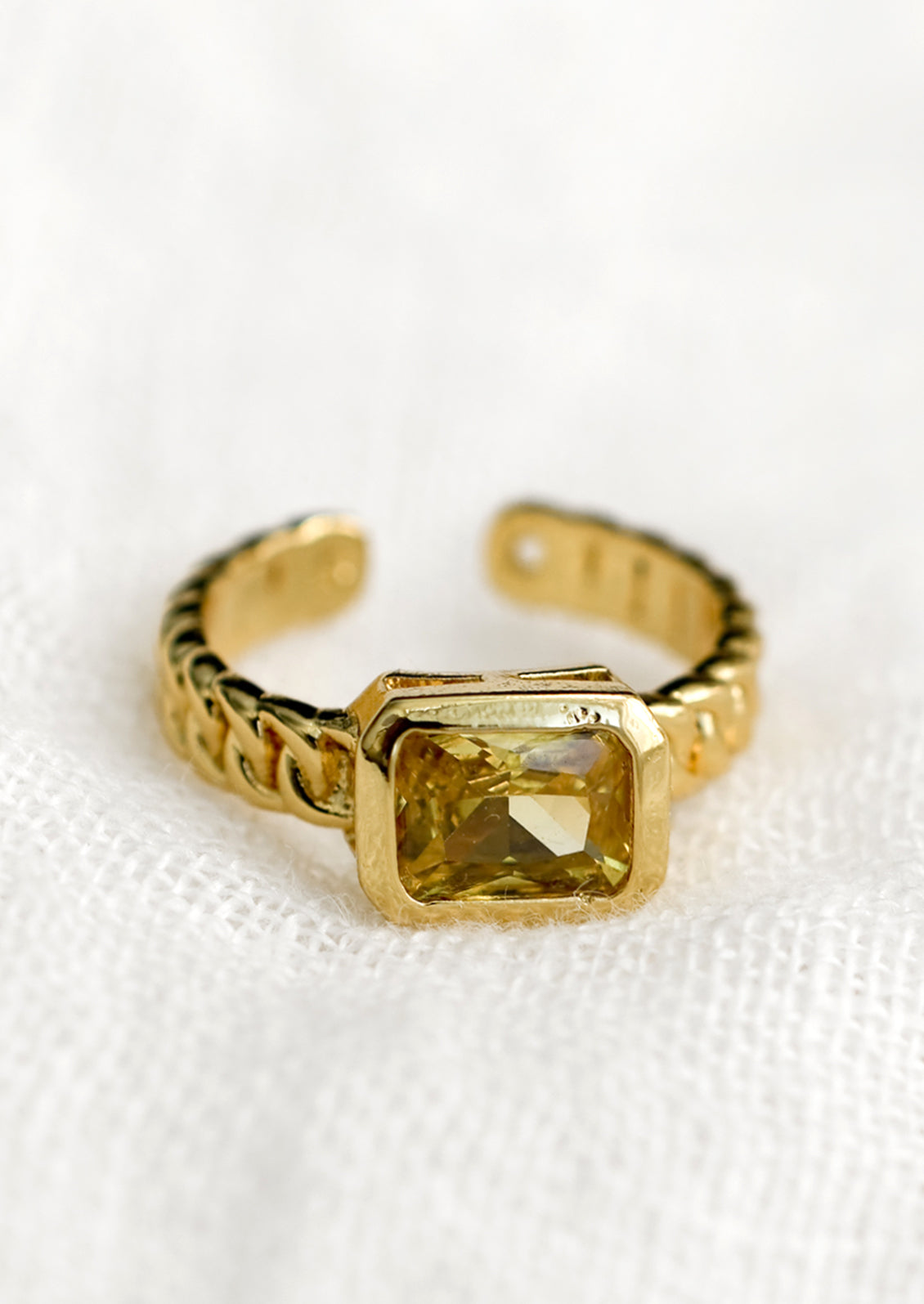 A gemstone ring with heavy chainlink band and rectangular citrine baguette.