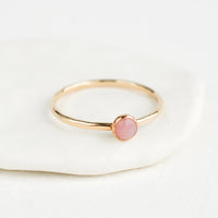 Pink Opal / Size 5: Thin gold ring with bezel set pink stone.