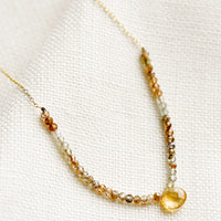Citrine / Quartz: A beaded necklace with small gemstone beads and citrine teardrop.