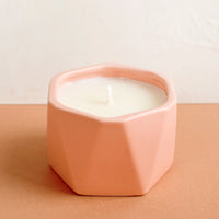 Paloma Petal: A small candle in peach faceted ceramic vessel.
