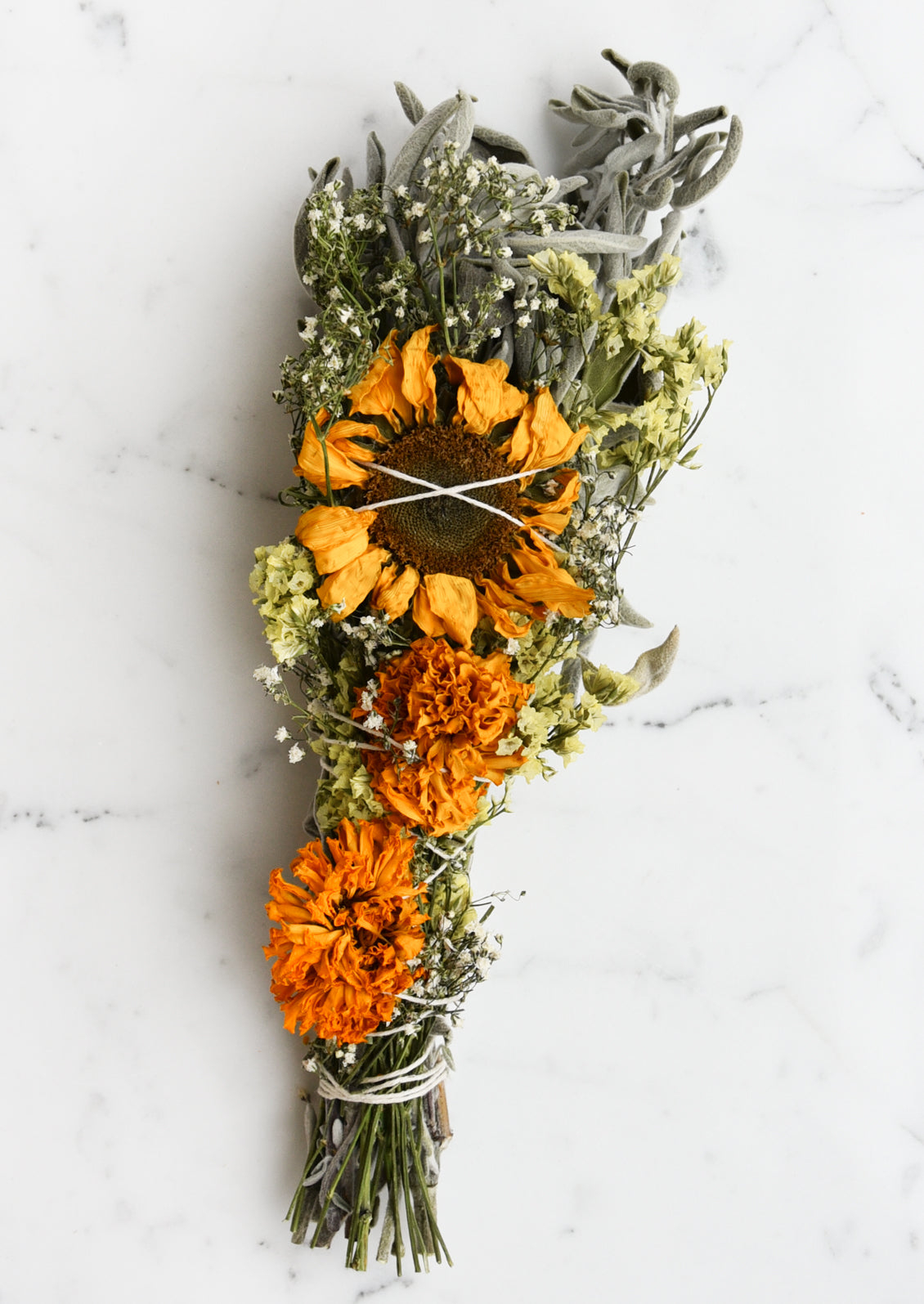 An extra large smudge bundle with sage, marigolds, and a single sunflower