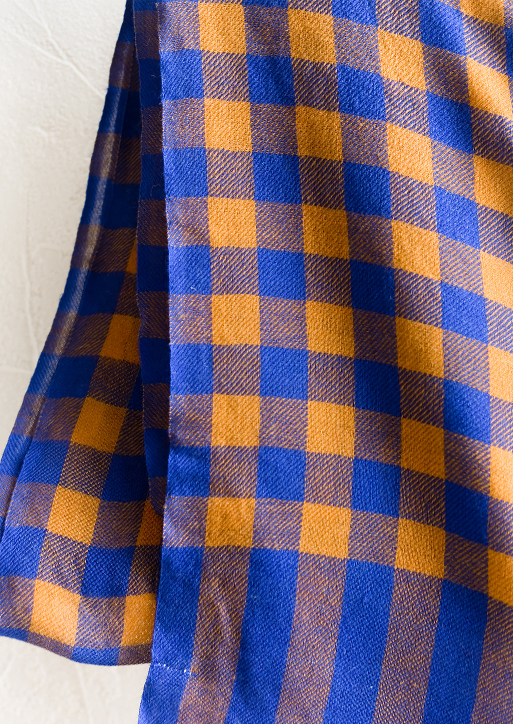 2: A lightweight woven wool scarf in blue and caramel gingham.