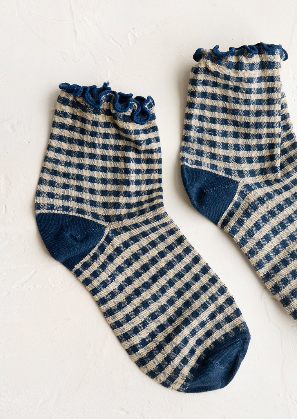 Ink Blue: A pair of dark blue gingham patterned socks with ankle ruffle.