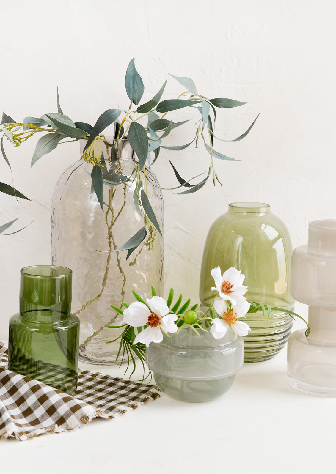 An assortment of decorative vases in green and grey glass.