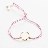 Orchid: Bracelet with yellow gold circle charm centered on an adjustable purple string.