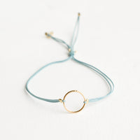 Teal: Bracelet with yellow gold circle charm centered on an adjustable teal string.