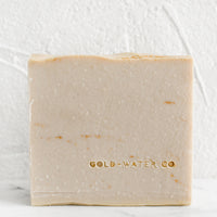 Santalum: A blush bar of soap with brand stamp at corner.