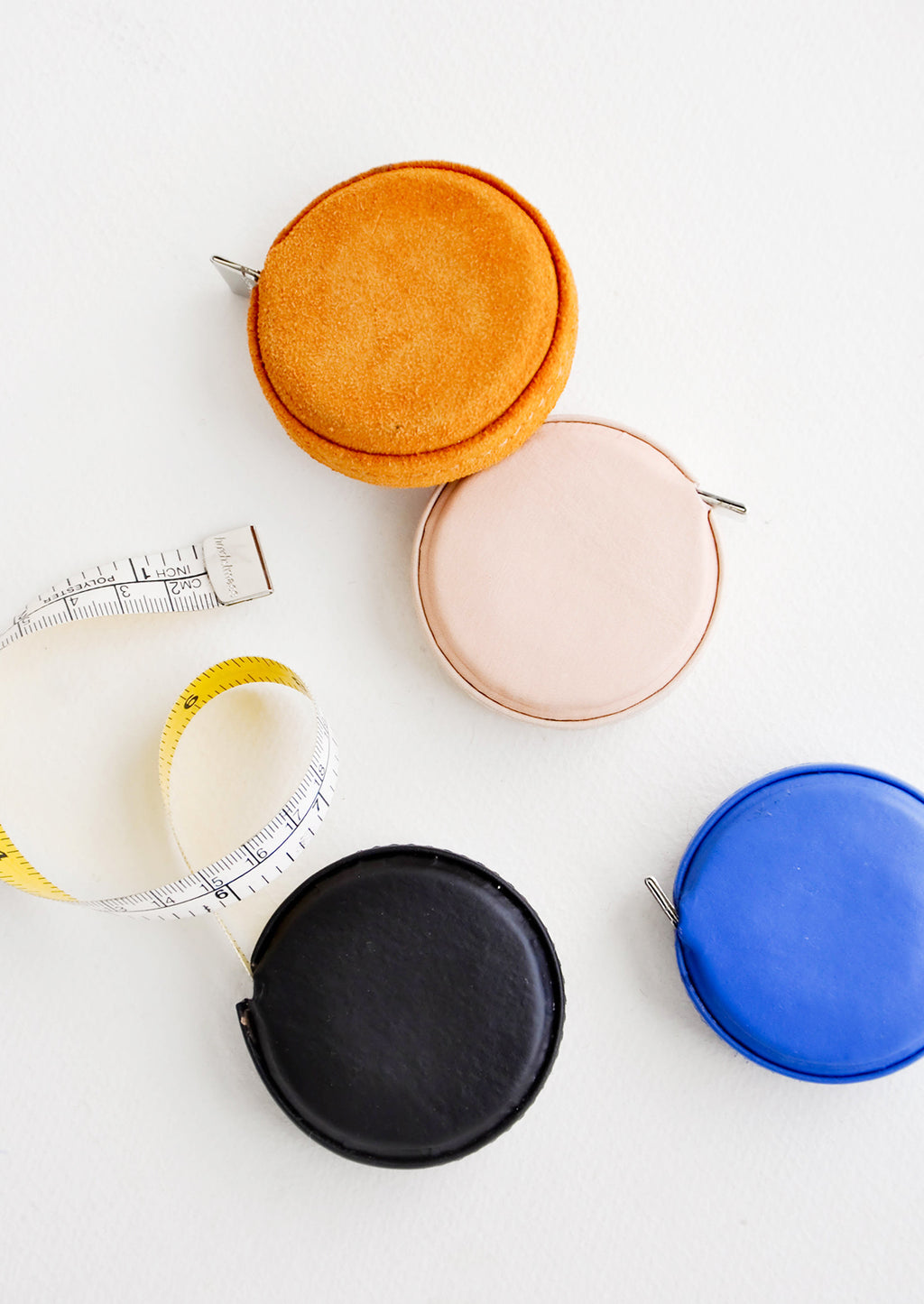 1: Product shot featuring multiple styles of leather covered tape measures.