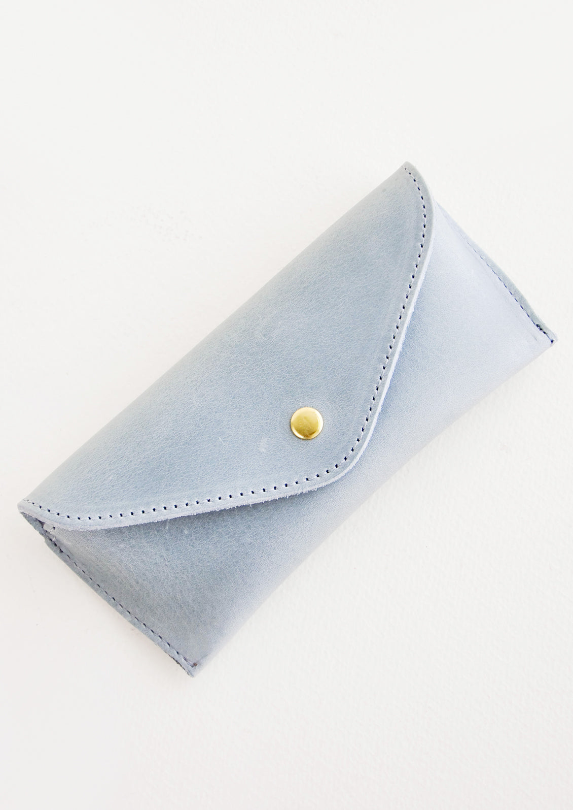 Dusty blue leather case for sunglasses that folds close with a snap.