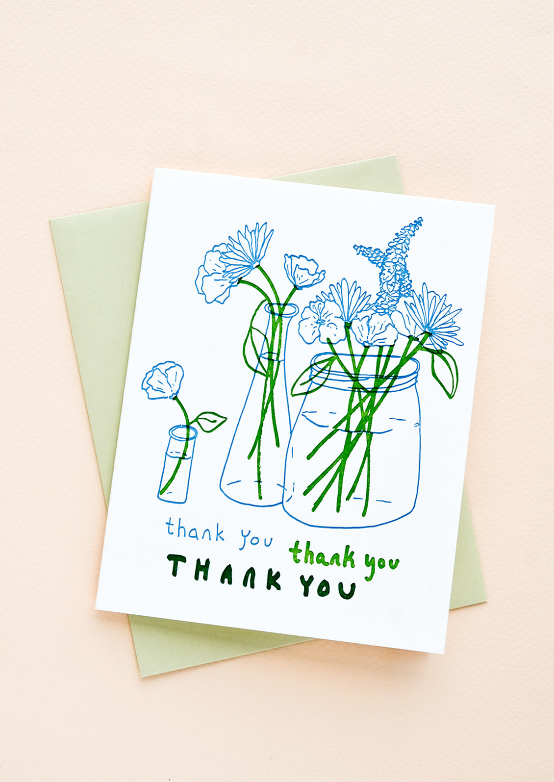 A letterpress printed thank you card with image of flowers in vases, with a mint green envelope.