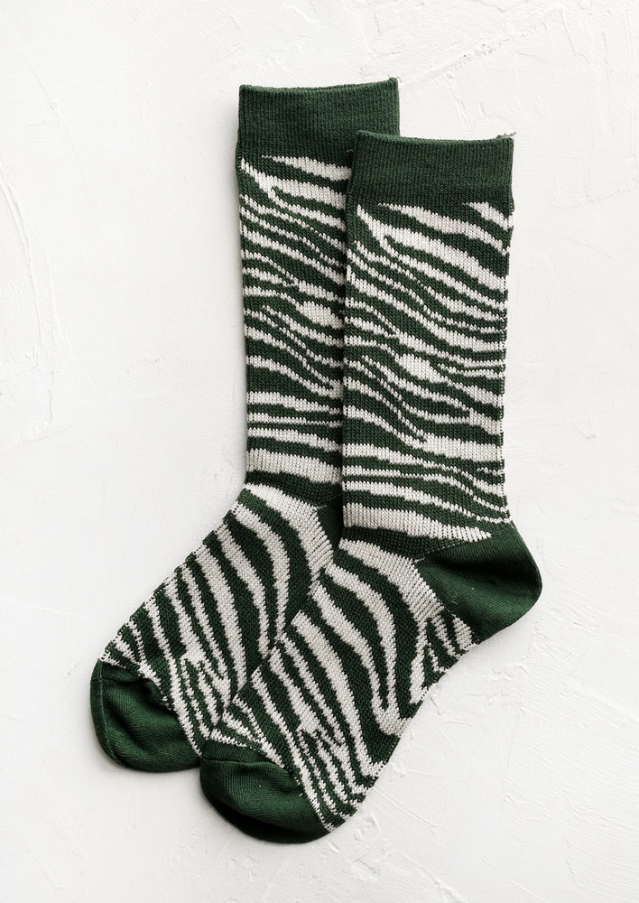A pair of zebra patterned socks in green and white.