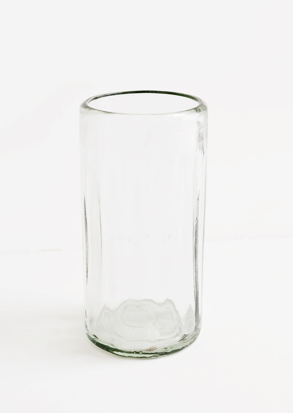 A horizontally ribbed tumblers in thick green hued glass.