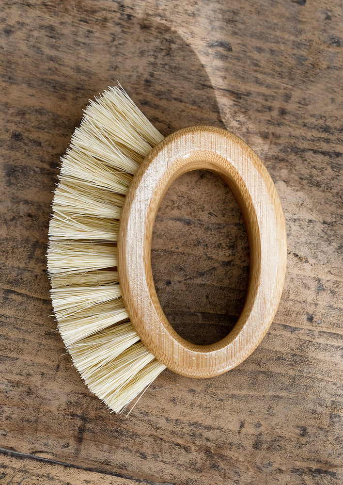 An oval shaped, open-handled scrubbing brush.