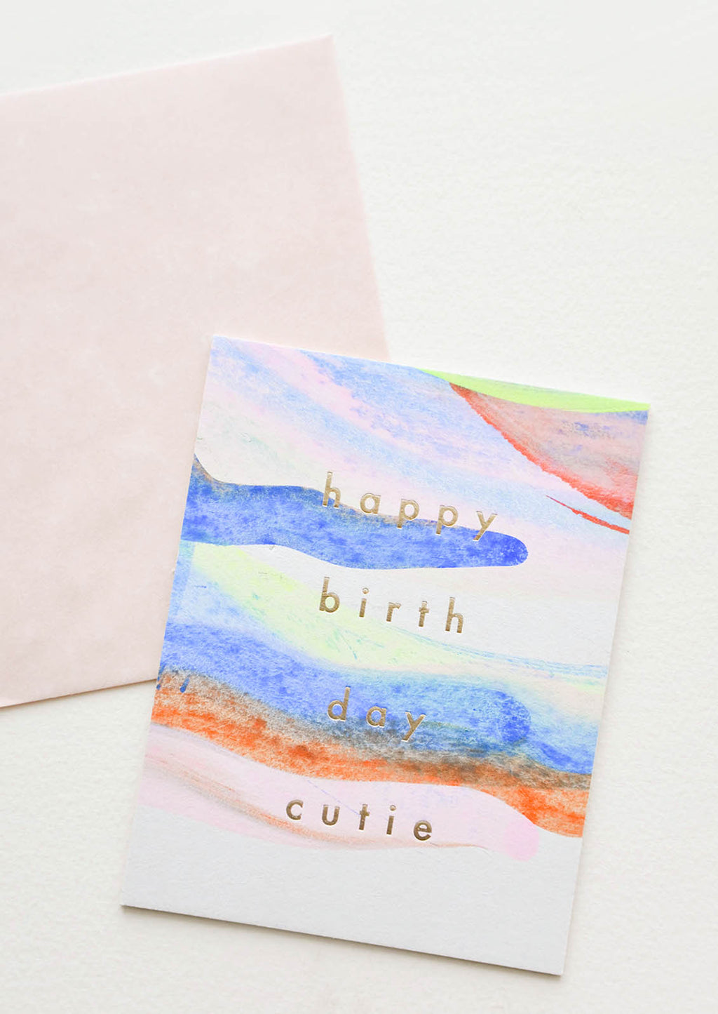 2: Notecard with pastel washed paint strokes and the text "Happy Birthday Cutie" in gold metallic, and pink envelope.