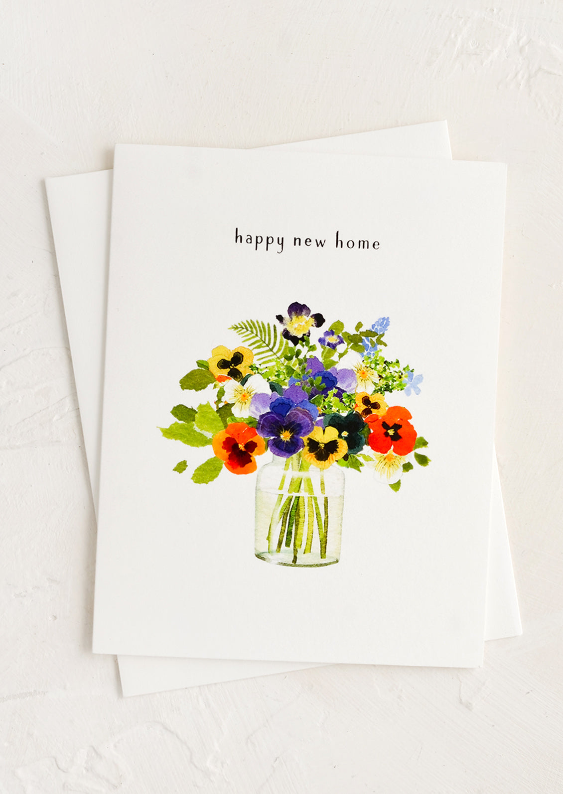 A greeting card with bouquet of flowers in a vase and text at top reading "happy new home".