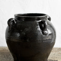 2: A dark brown (almost black) ceramic jar with decorative loop handles.