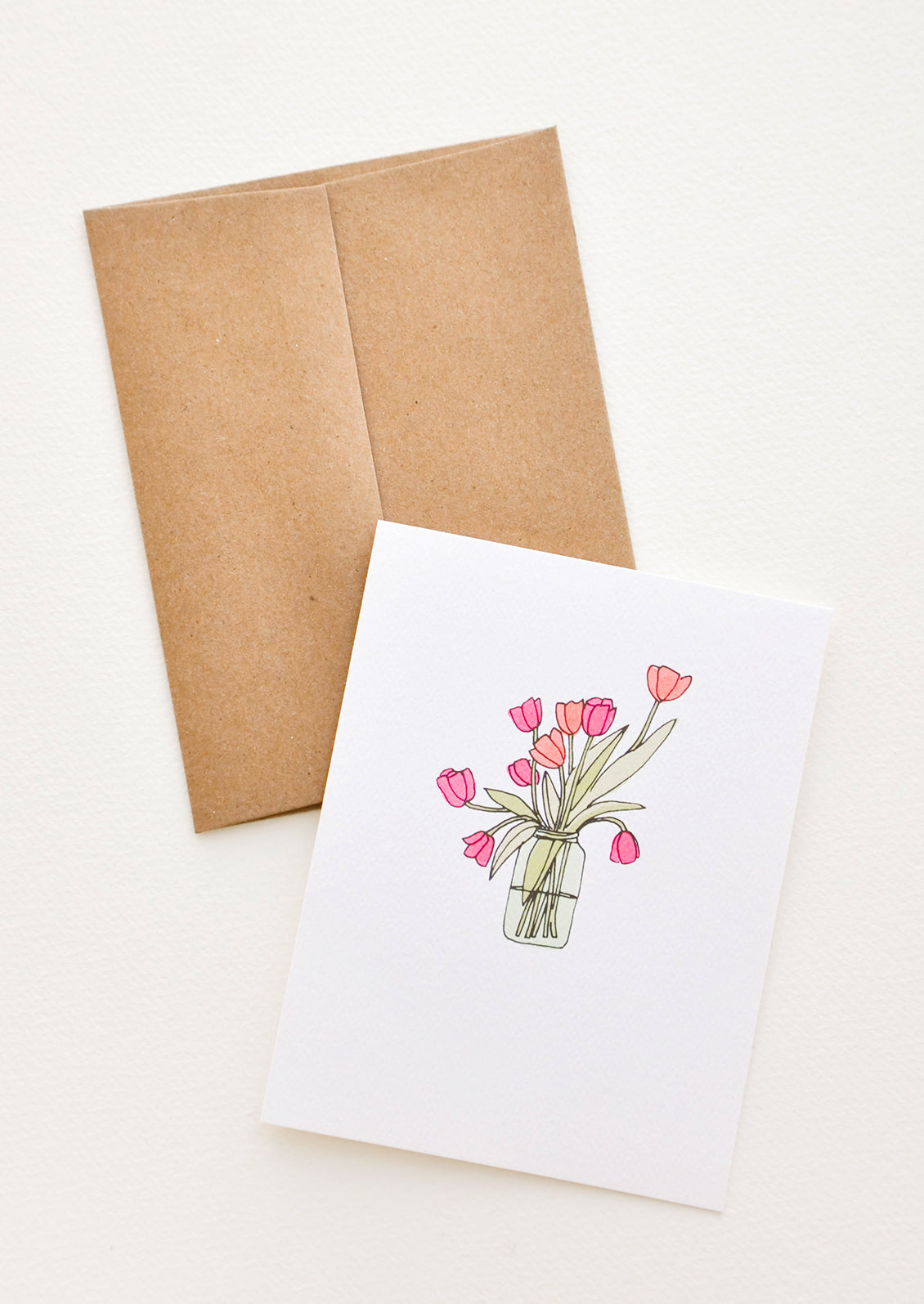 A greeting card with illustration of tulips in a glass vase.