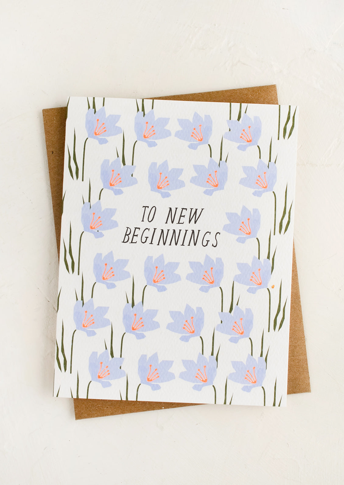 A floral printed greeting card with text reading "To New Beginnings".