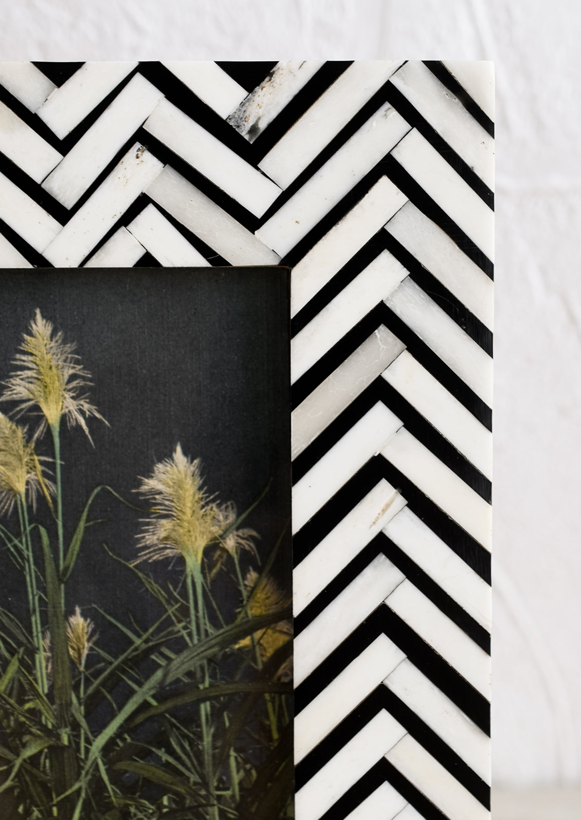 A bone picture frame with black and white chevron pattern.
