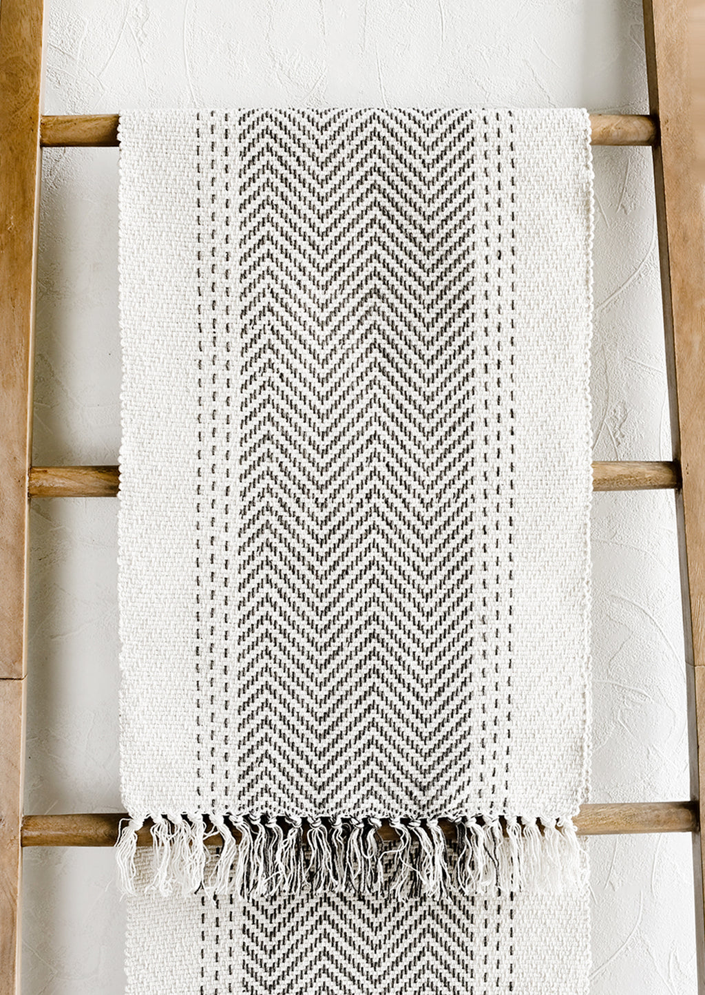 1: A cream textured cotton table runner with herringbone stitch down middle.