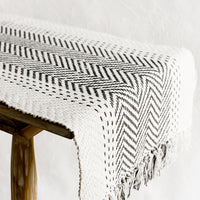 2: A cream textured cotton table runner with herringbone stitch down middle.