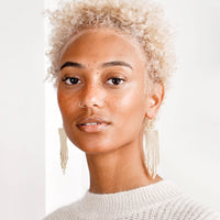 3: Model wears ivory beaded fringe earrings and white sweater.