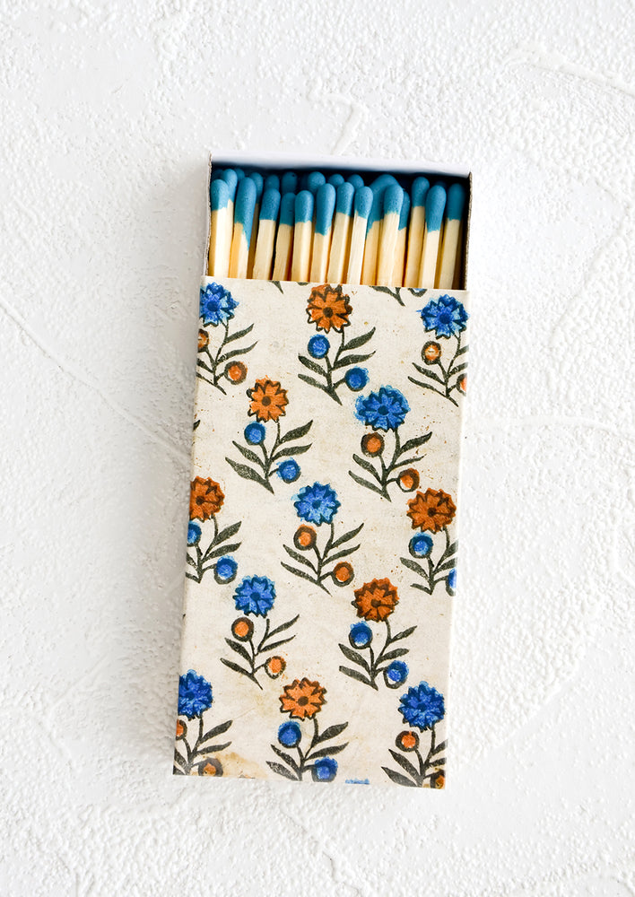 Matchbox with blue and red block print floral pattern, housing long matches with turquoise tips