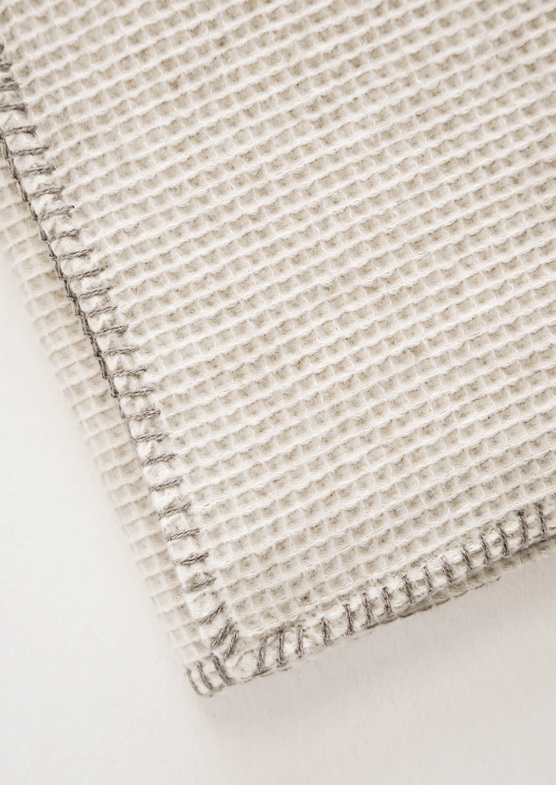 Honeycomb Waffle Weave Blanket in Oatmeal with whipstitching around edges