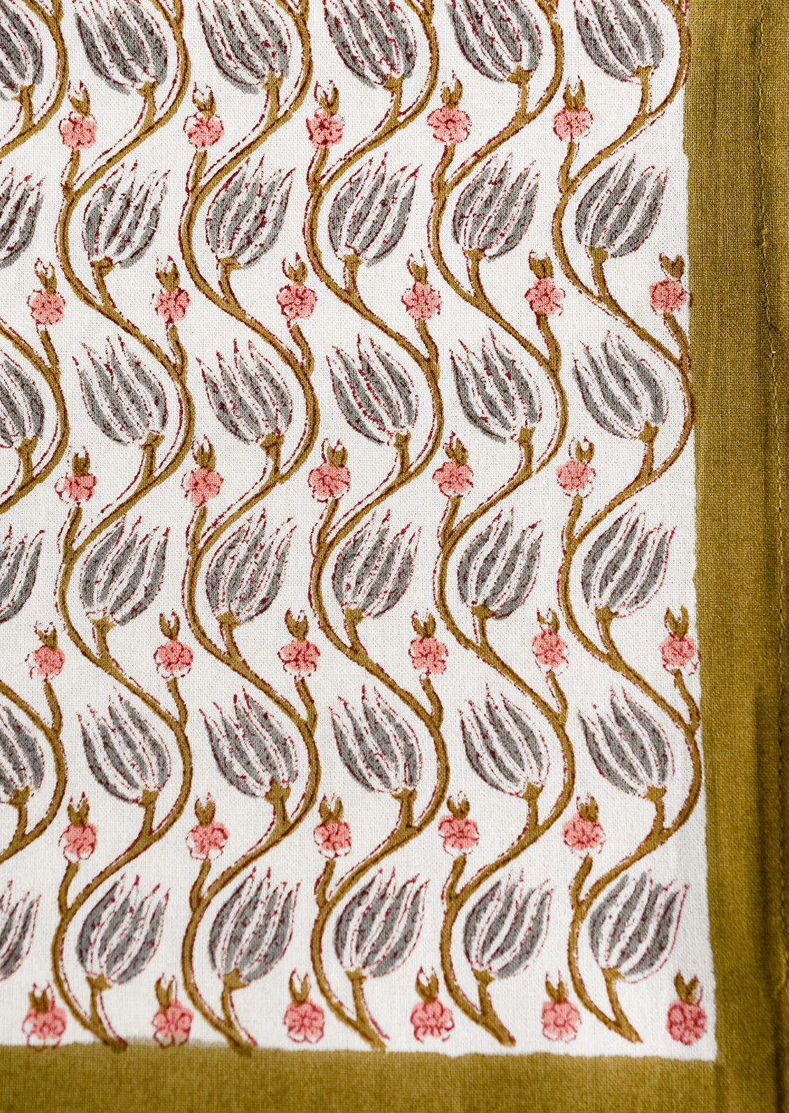 A botanical print tablecloth with khaki green trim.