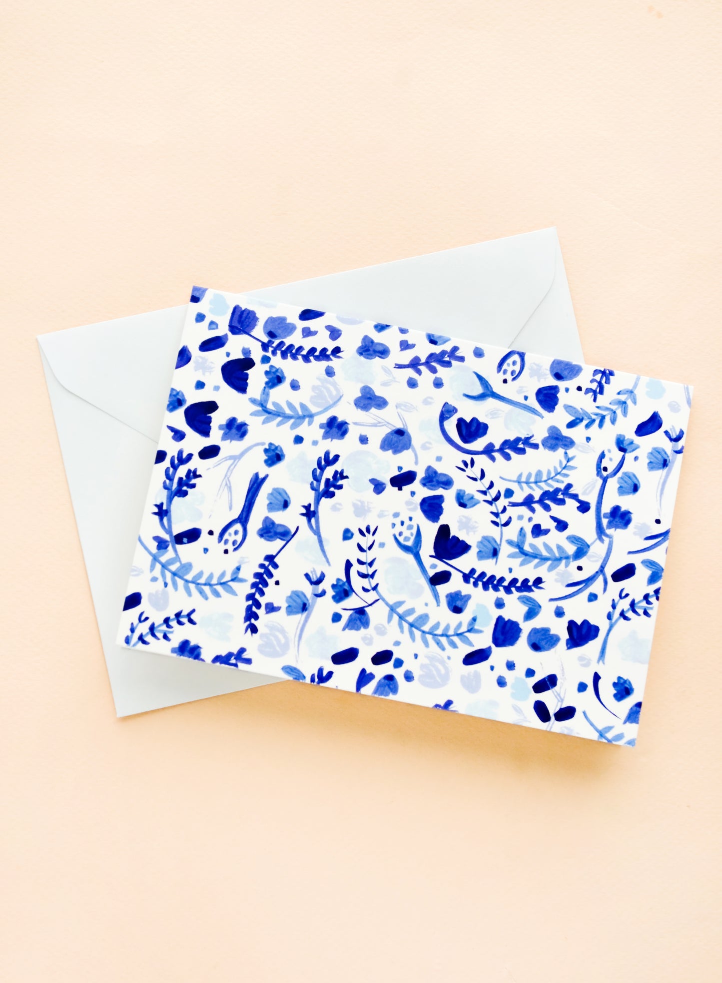 A greeting card with white and blue watercolor floral print, paired with light blue envelope.