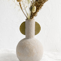 2: A sculptural ceramic vase with dried flowers.