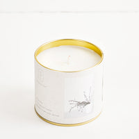 Vetiver Sage: A candle in a brass tin with a gray label featuring a picture of grasses.