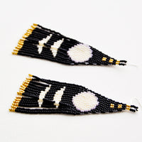 3: Dangling earrings with black and white geometric beaded shapes and black and gold beaded fringe.