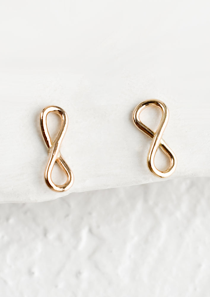 1: A pair of gold stud earrings in infinity loop shape.