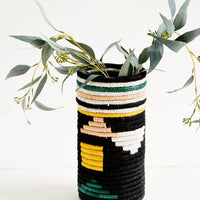 Black Geo Multi: Tall vases made of woven natural grass in colorful geometric pattern, with eucalyptus leaves inside